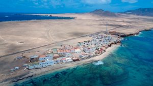 A coastal town sits on a sandy strip.