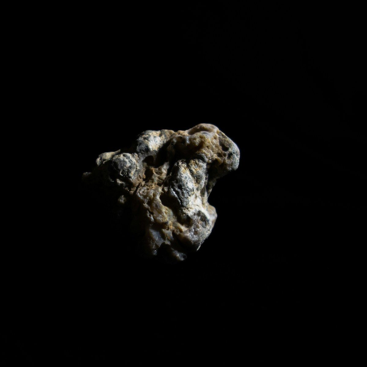 a rock in the dark on a black background